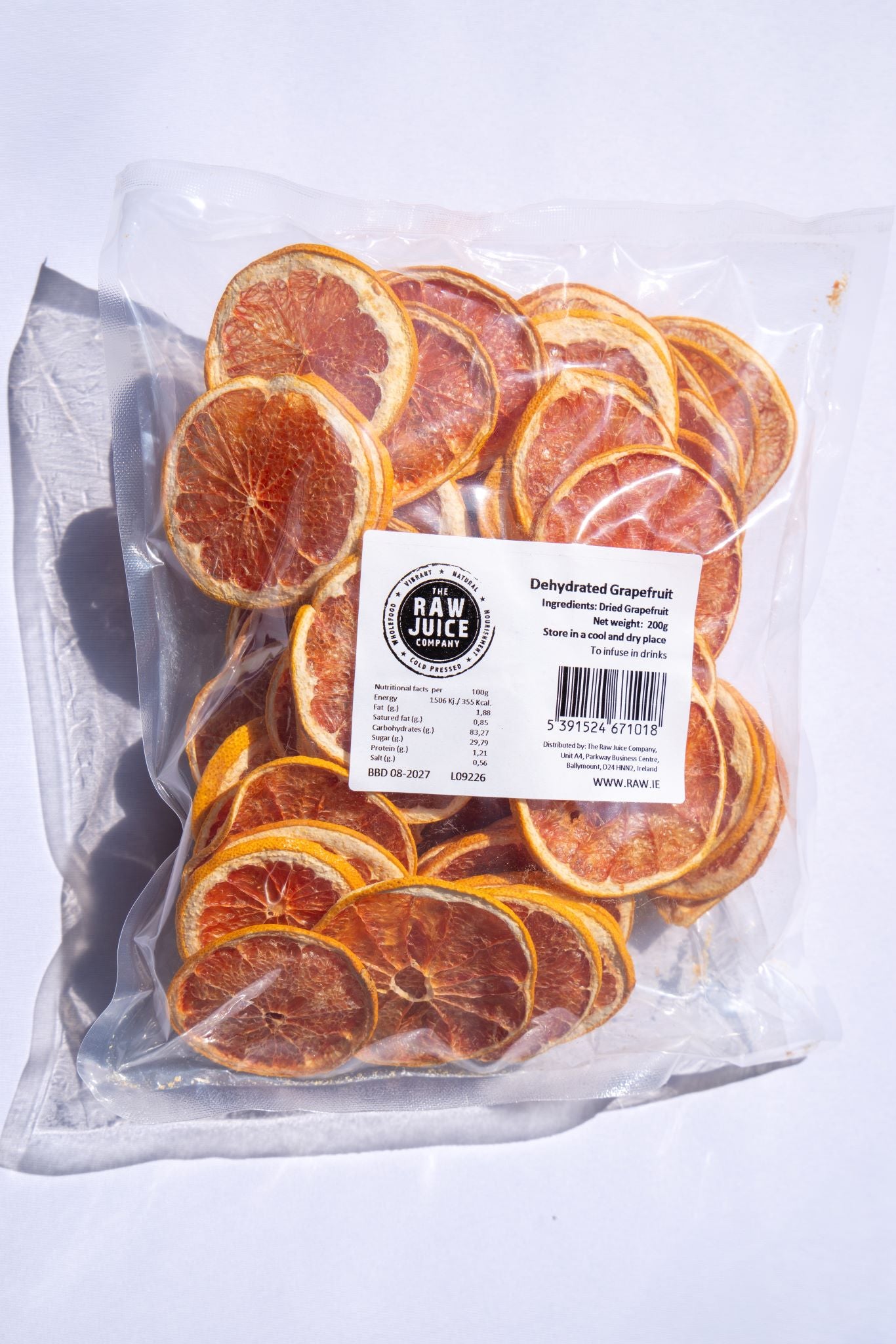 A clear plastic bag filled with dried orange slices, with a white label reading 'RAW JUICE' and 'Dehydrated Citrusfruit' on a white background.